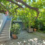 A patio with stairs and potted plants in the middle of it.