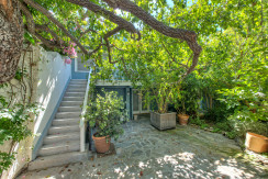 A patio with stairs and potted plants in the middle of it.