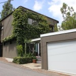 A house with a garage door and some trees
