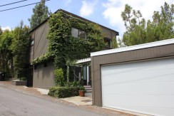 A house with a garage door and some trees