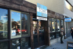 A person standing outside of a store front.