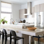 A kitchen with a counter and chairs in it