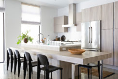 A kitchen with a counter and chairs in it