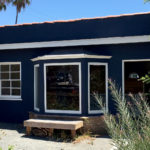 A blue building with a bench outside of it.