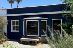 A blue building with a bench outside of it.