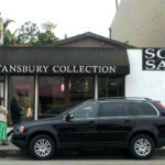 A black suv parked in front of a store.
