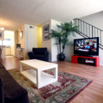 A living room with a couch, chair and television.