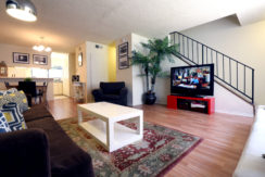 A living room with a couch, chair and television.