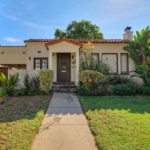 A house with a sidewalk and grass in front of it.