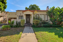 A house with a sidewalk and grass in front of it.