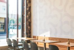 A restaurant with tables and chairs in front of the window.