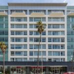 A large building with palm trees in front of it.
