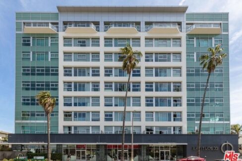 A large building with palm trees in front of it.