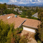 A house with brown roof and white garage.