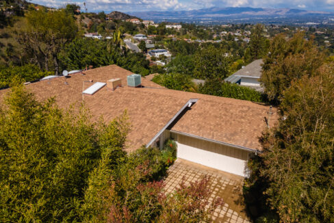 A house with brown roof and white garage.